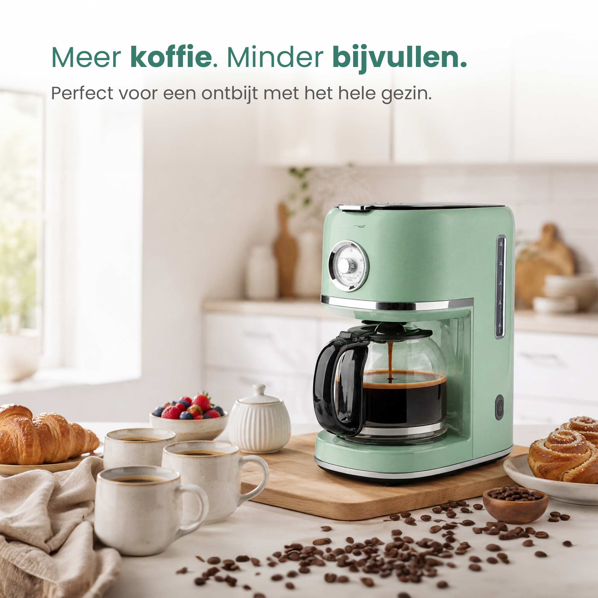 Green coffee maker brewing coffee. Croissants, berries, buns, and mugs are nearby.