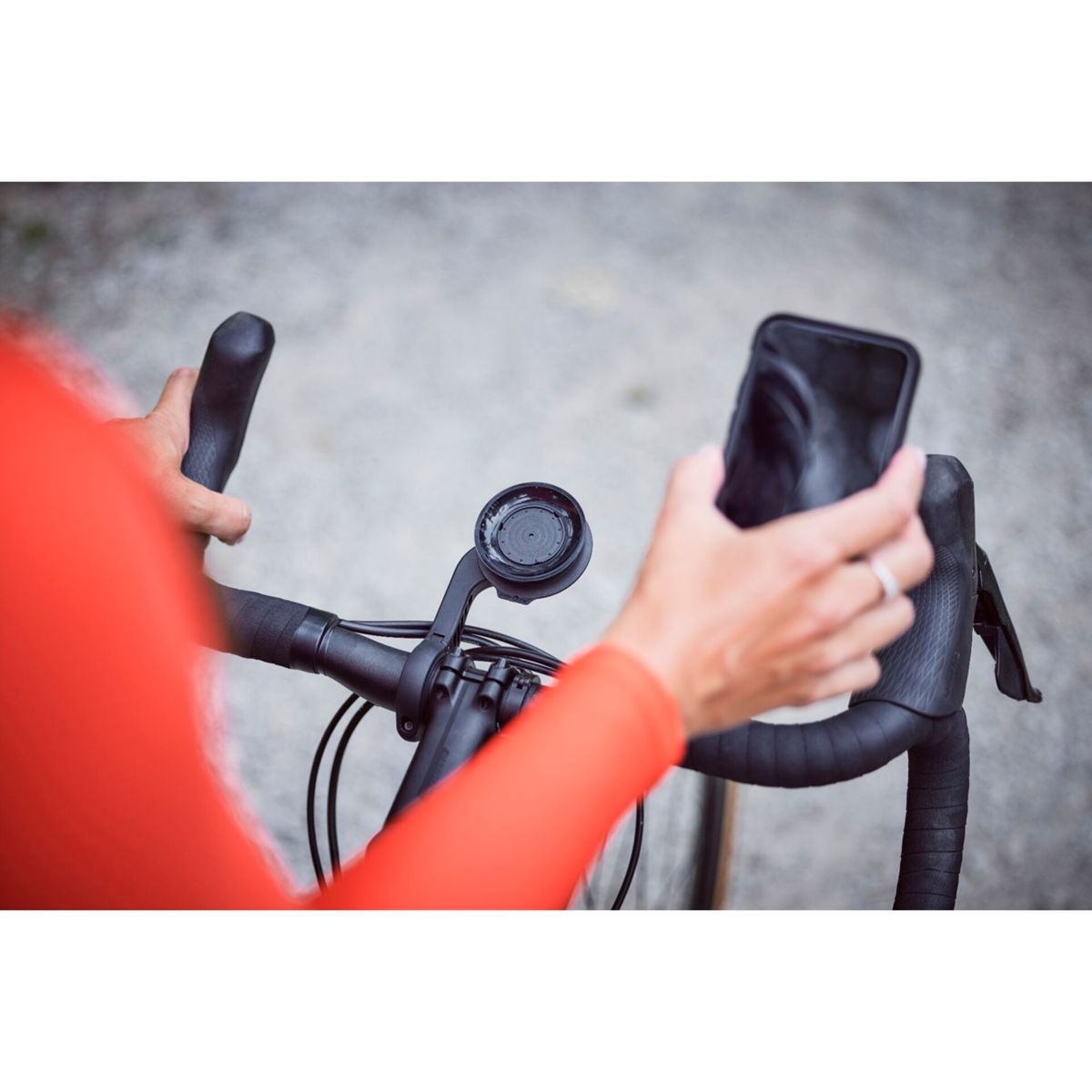 Ciclista tiene smartphone sopra manubrio bici con supporto computer.
