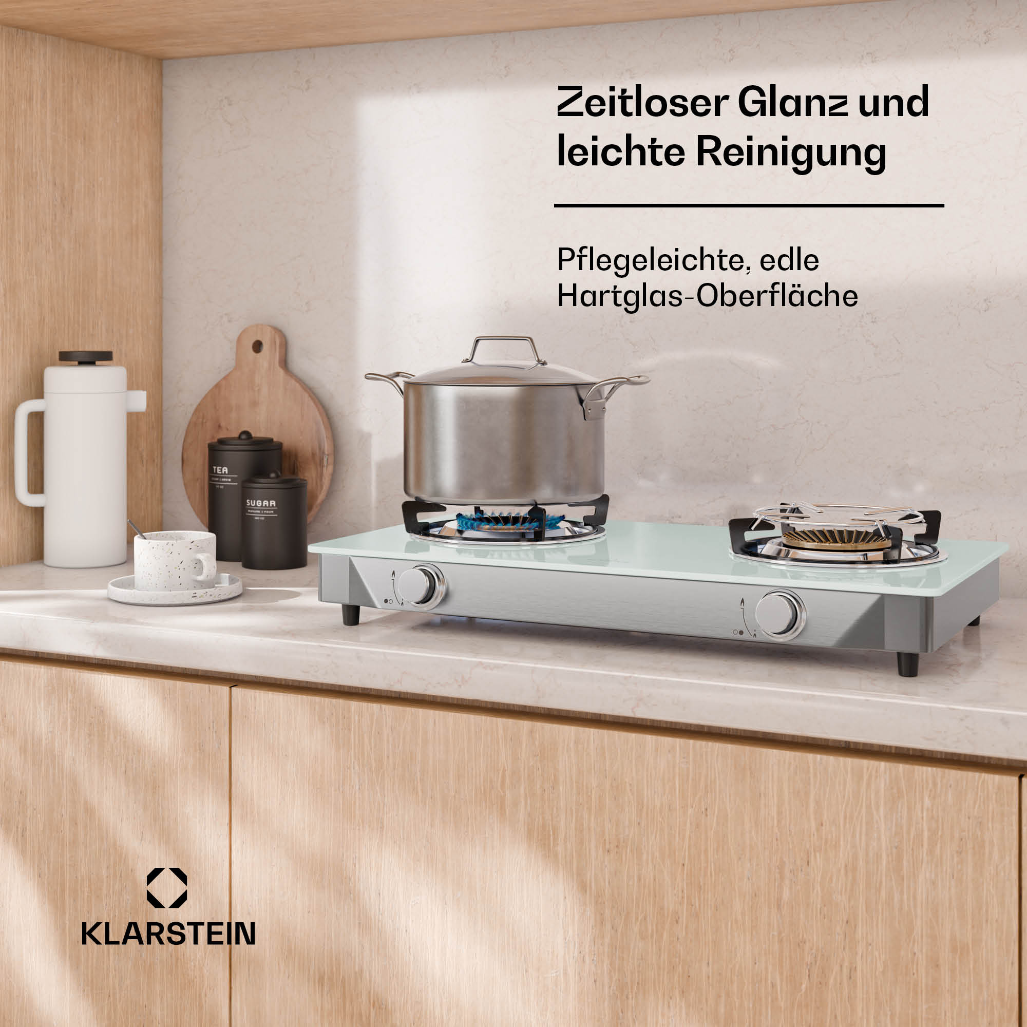 Ein Kochfeld mit Topf und Bechern auf einem Küchenarbeitsplatz.