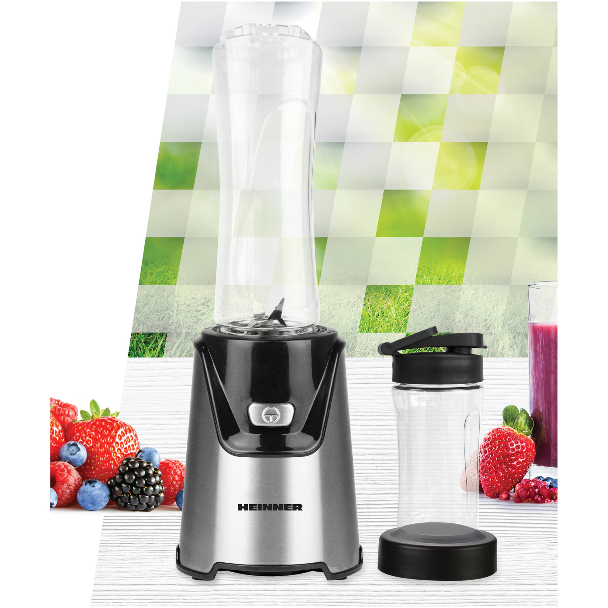 Ein schwarzer und silberner Mixer steht neben einer leeren Trinkflasche und Beeren.