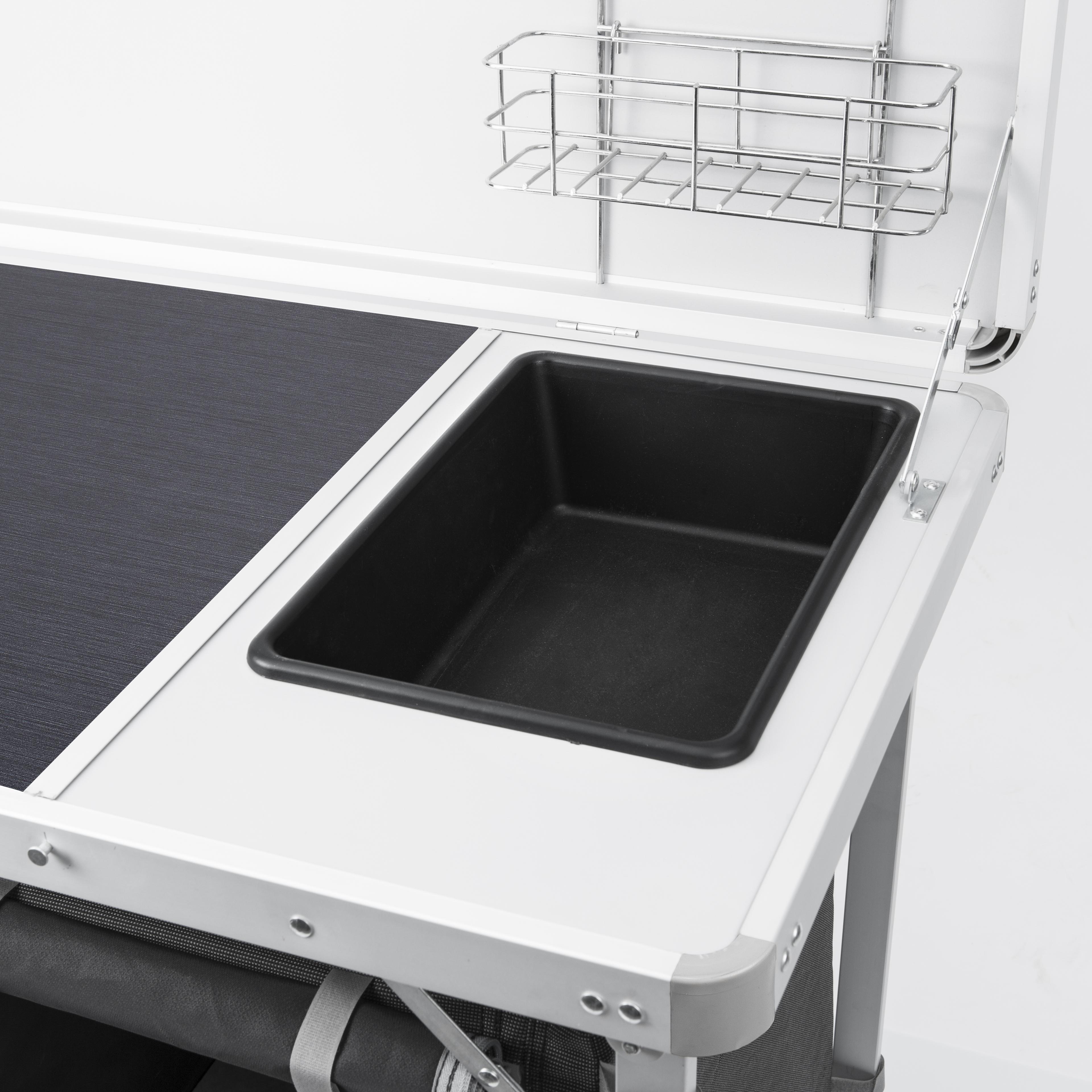 Klappbarer Campingtisch mit schwarzem Spülbecken und silbernem Drahtkorb.