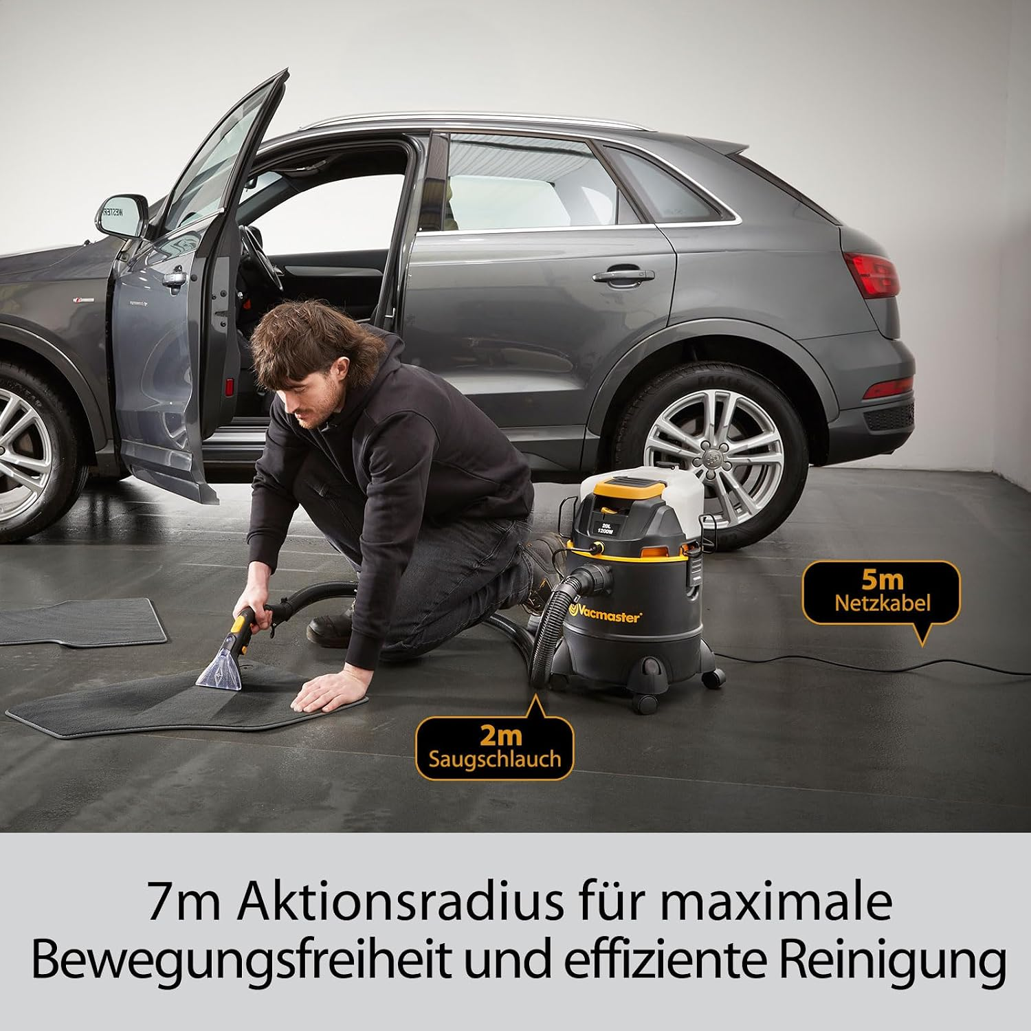 Mann reinigt Autoteppiche mit Nass-/Trockensauger neben einem grauen SUV.