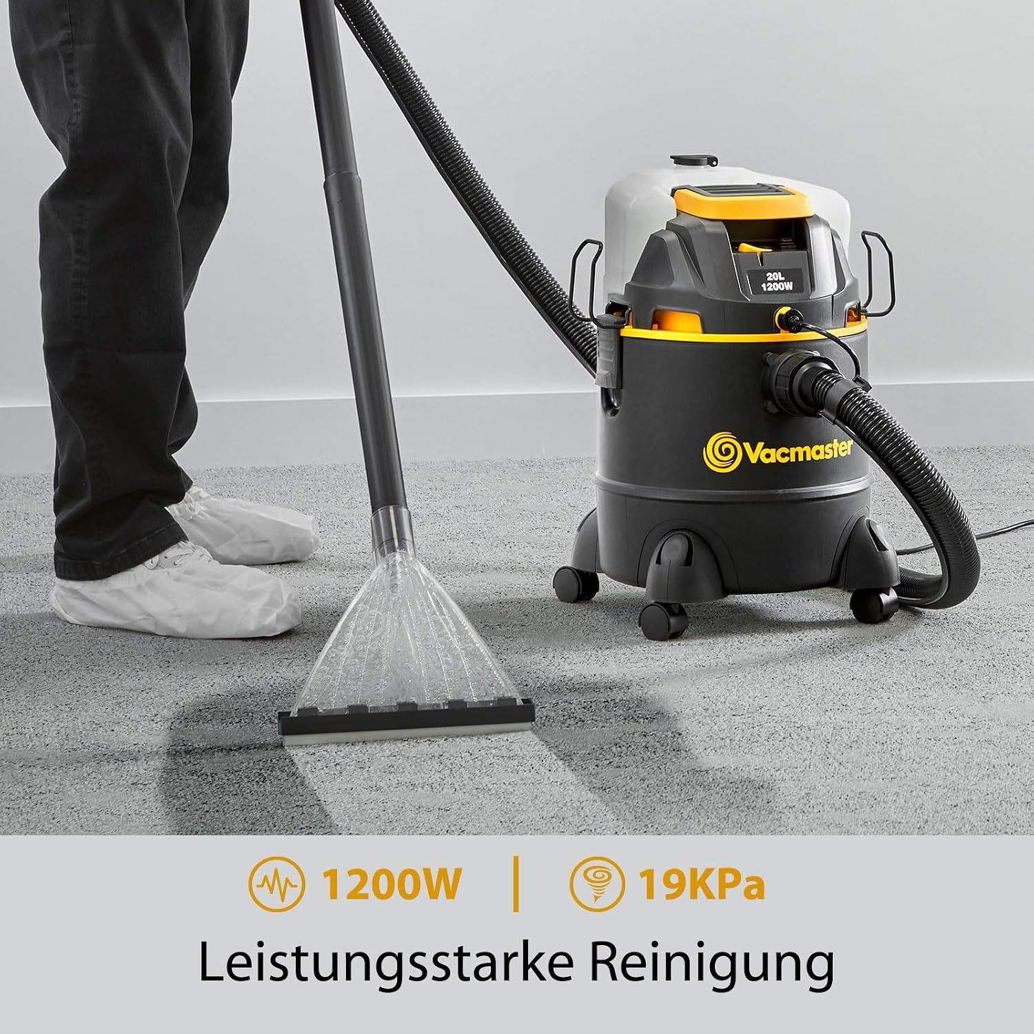Ein Mann reinigt Teppichboden mit einem gelben und schwarzen Nass-/Trockensauger von Vacmaster.
