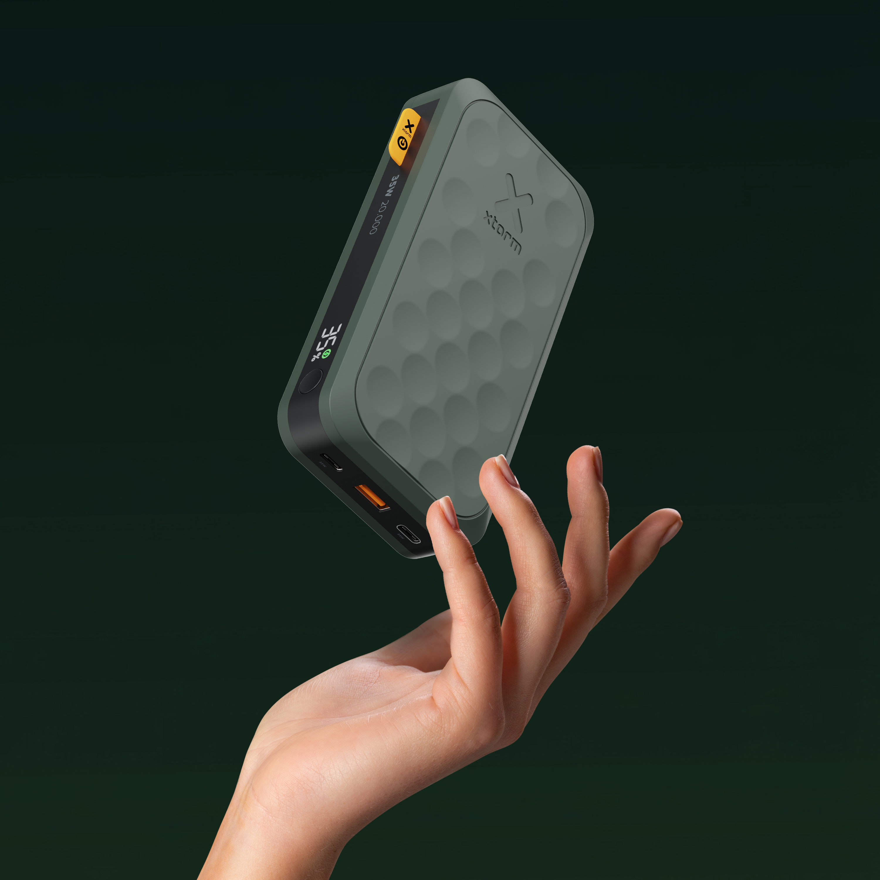 Eine grüne Powerbank mit Wabenmuster schwebt über einer Hand.