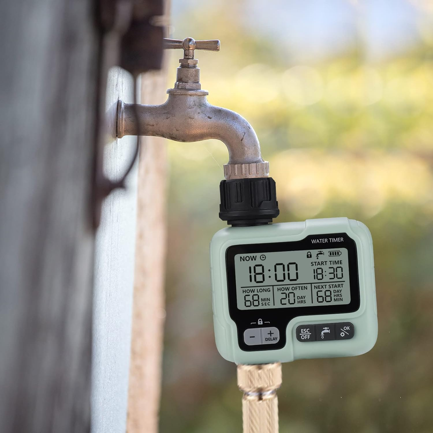 Ein digitaler Bewässerungszeitschaltuhr ist an einem Wasserhahn mit einem Schlauchanschluss befestigt.