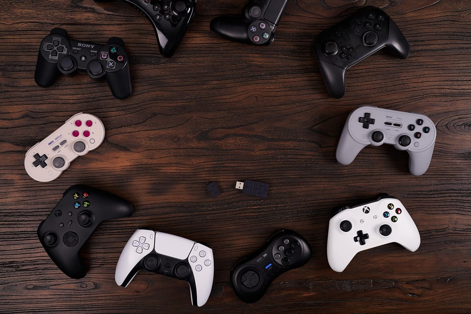 Verschiedene Videospiel-Controller und USB-Adapter auf Holzoberfläche angeordnet.