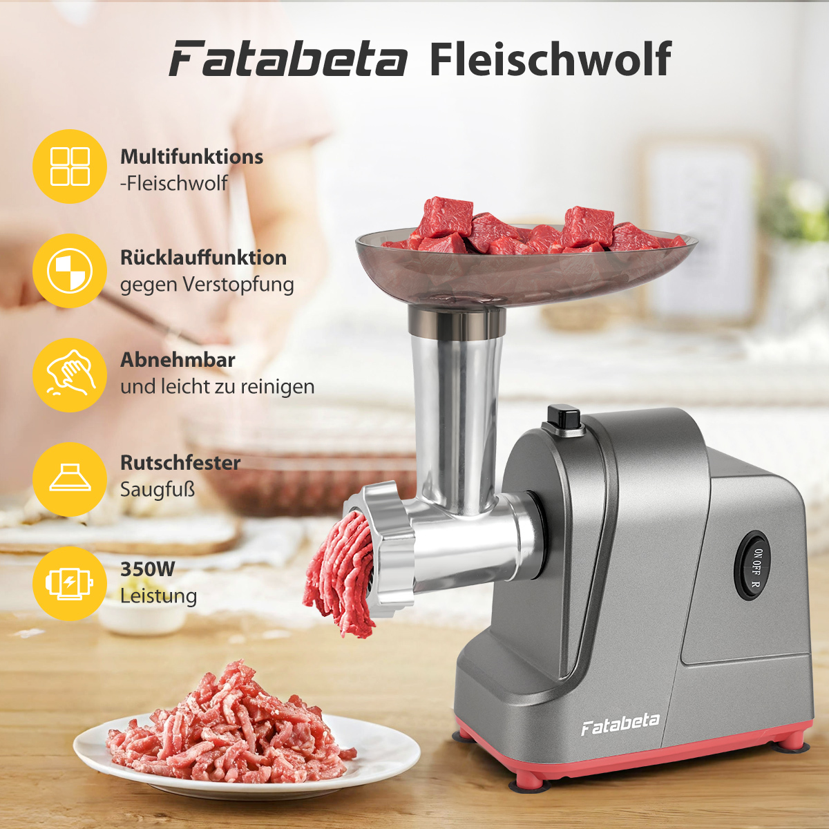Ein grauer Fleischwolf von Fatabeta mit rotem Sockel, der Fleisch mahlt. Daneben ist ein Teller mit gemahlenem Fleisch.