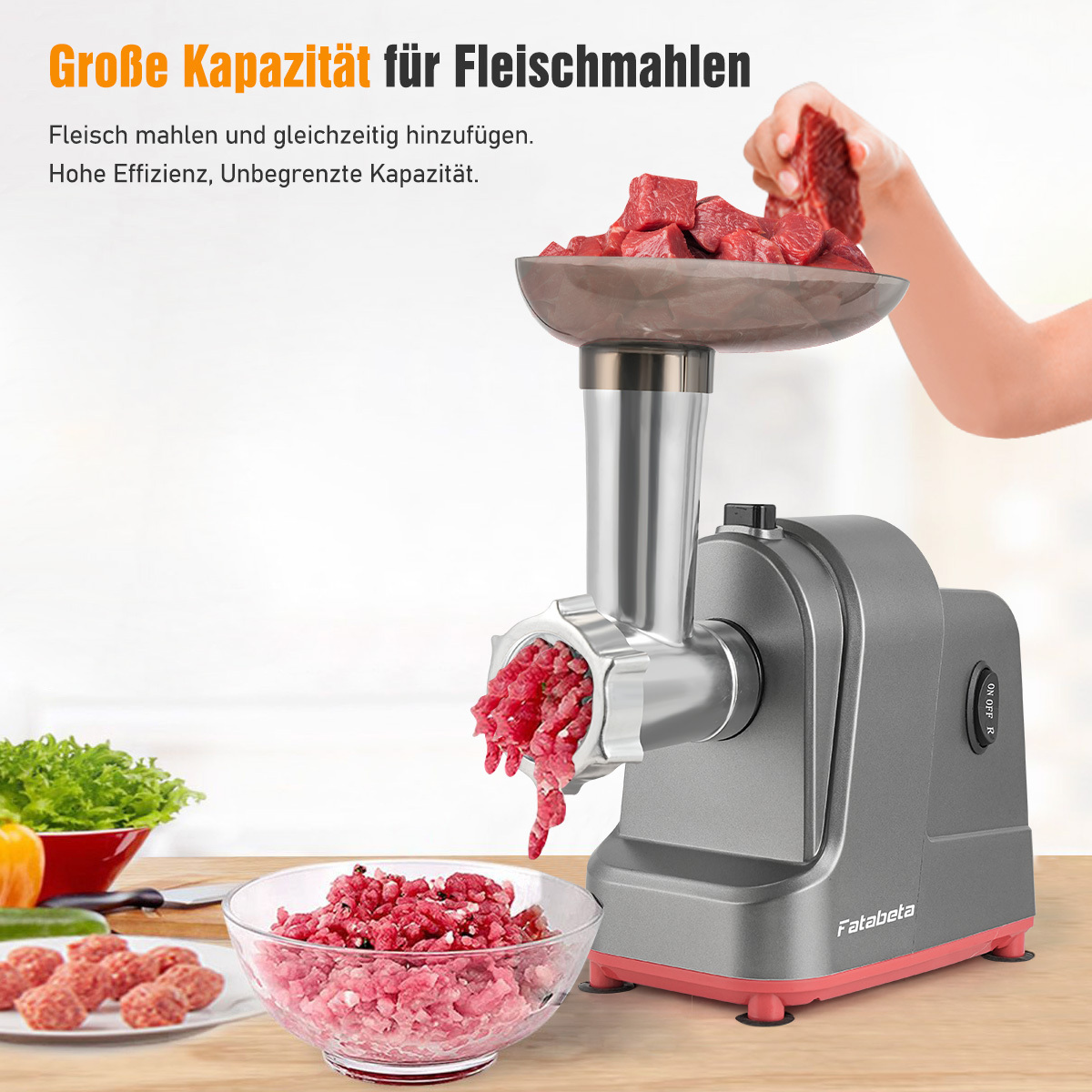 Ein Fleischwolf verarbeitet Fleisch. Eine Hand füllt Würfel ein. Gemahlenes Fleisch liegt in einer Schüssel.