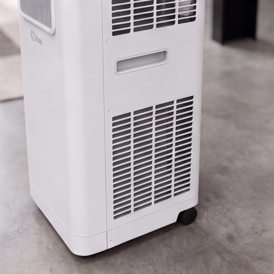 Una torre bianca di condizionatore portatile con ruote su pavimento in cemento.