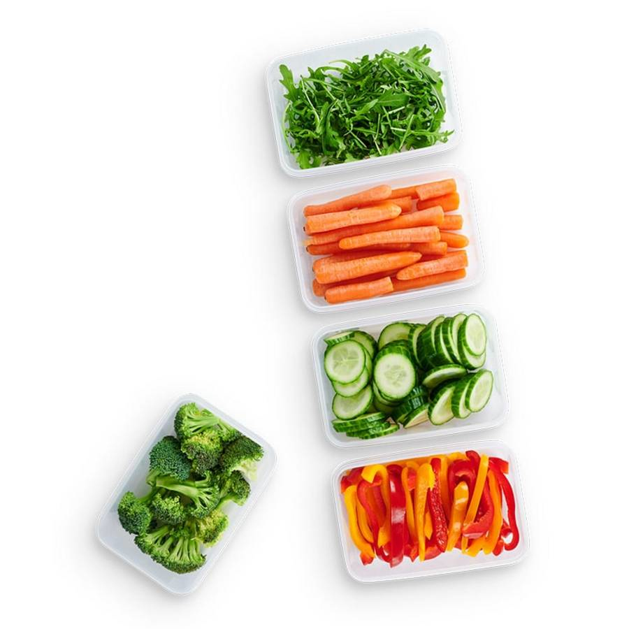 Vier durchsichtige Behälter mit gehacktem Gemüse: Rucola, Karotten, Gurkenscheiben und Paprika.