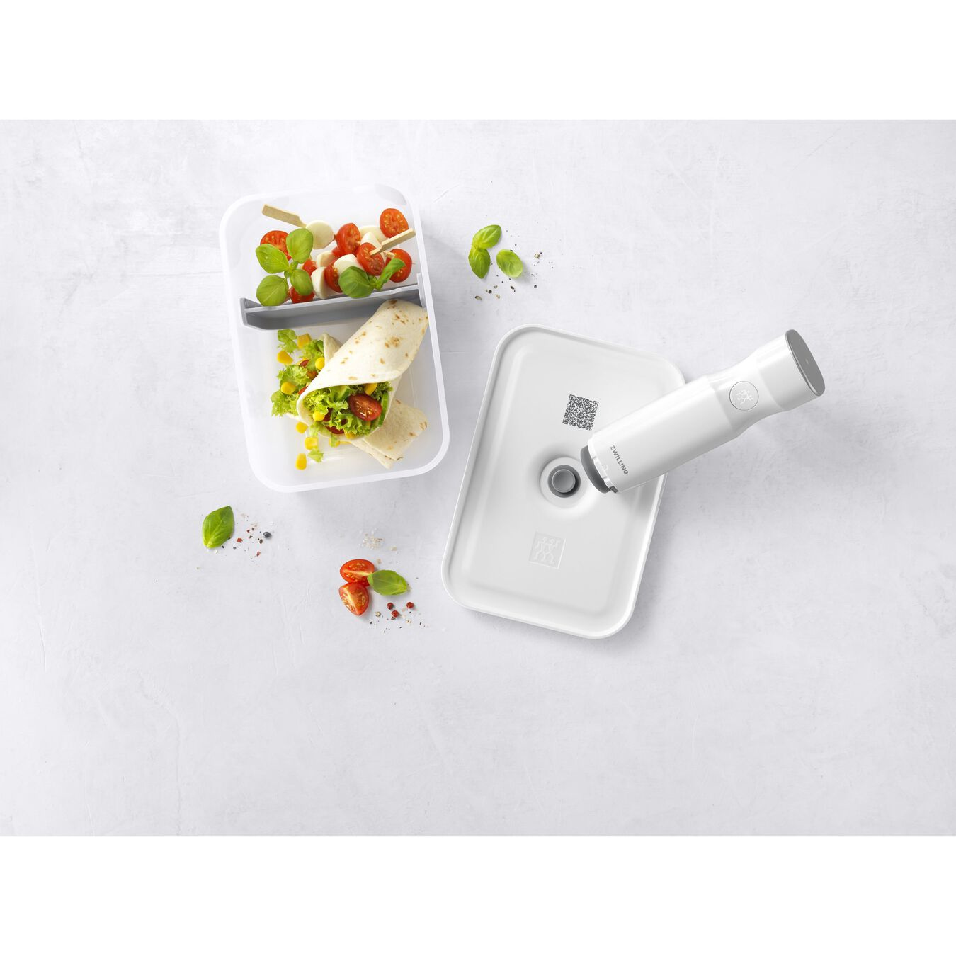 Un contenitore bianco con cibo e un sottovuoto su sfondo bianco.