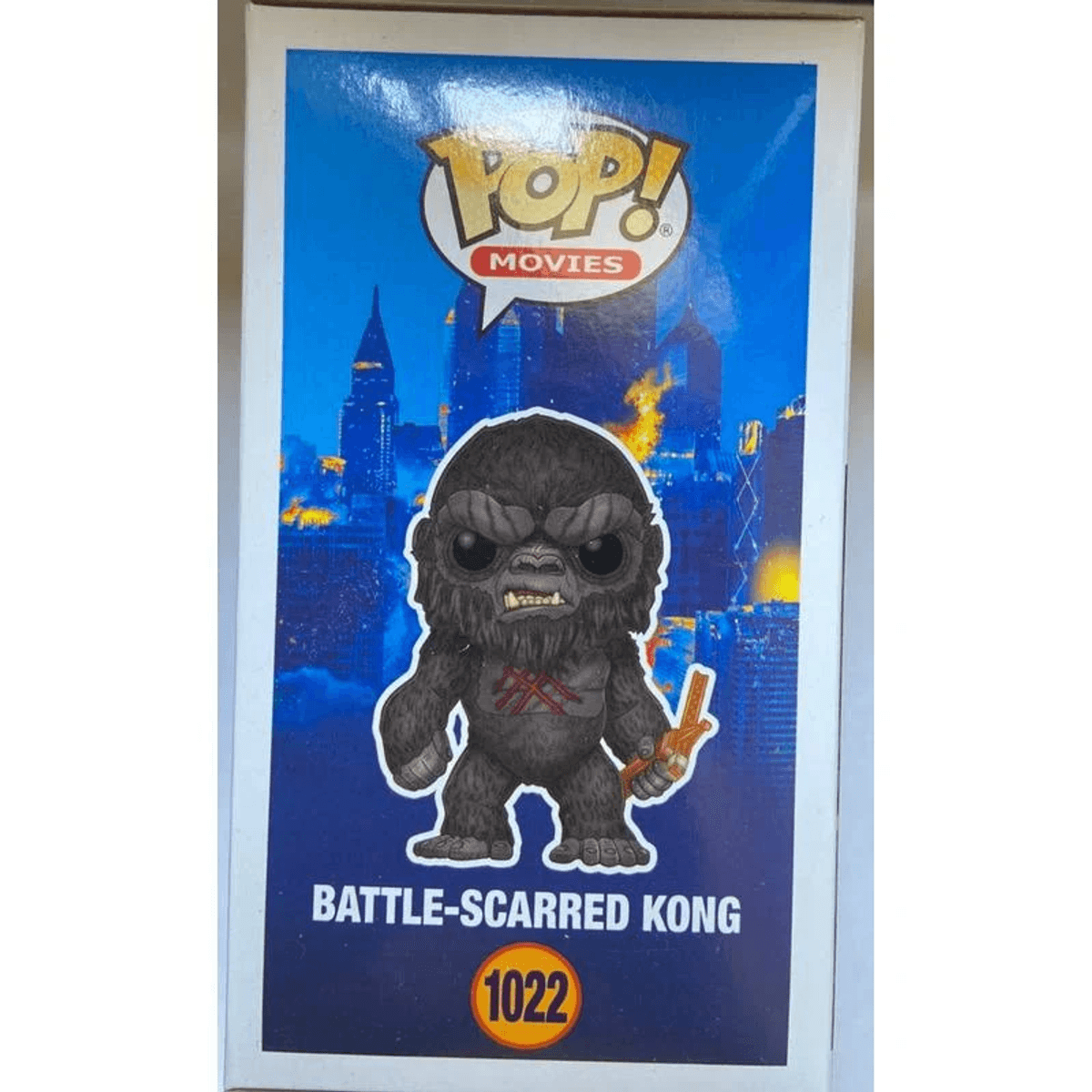 Una figura Funko Pop! de Battle-Scarred Kong con fondo de ciudad.