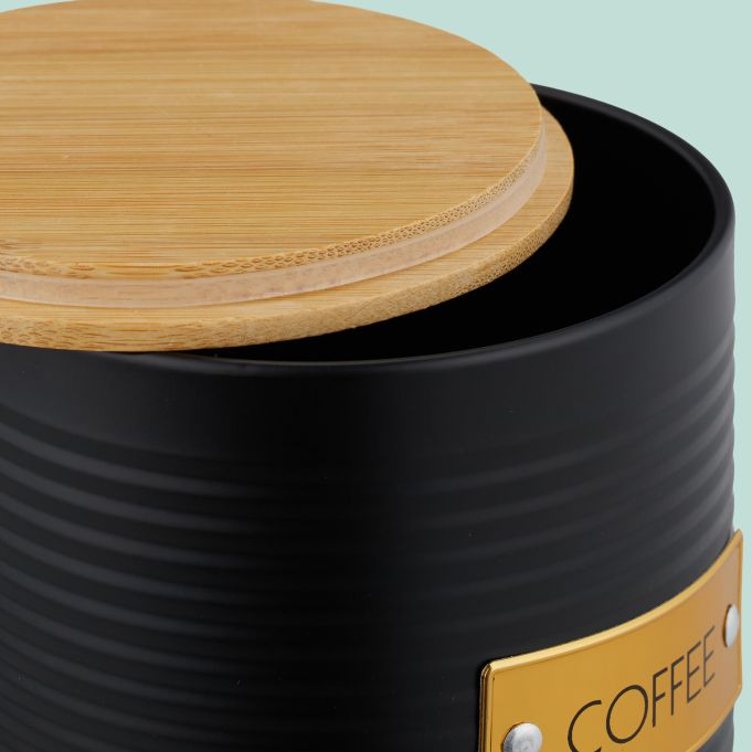 Schwarzer Kaffeebehälter mit Holzdeckel und goldener „COFFEE“-Plakette.