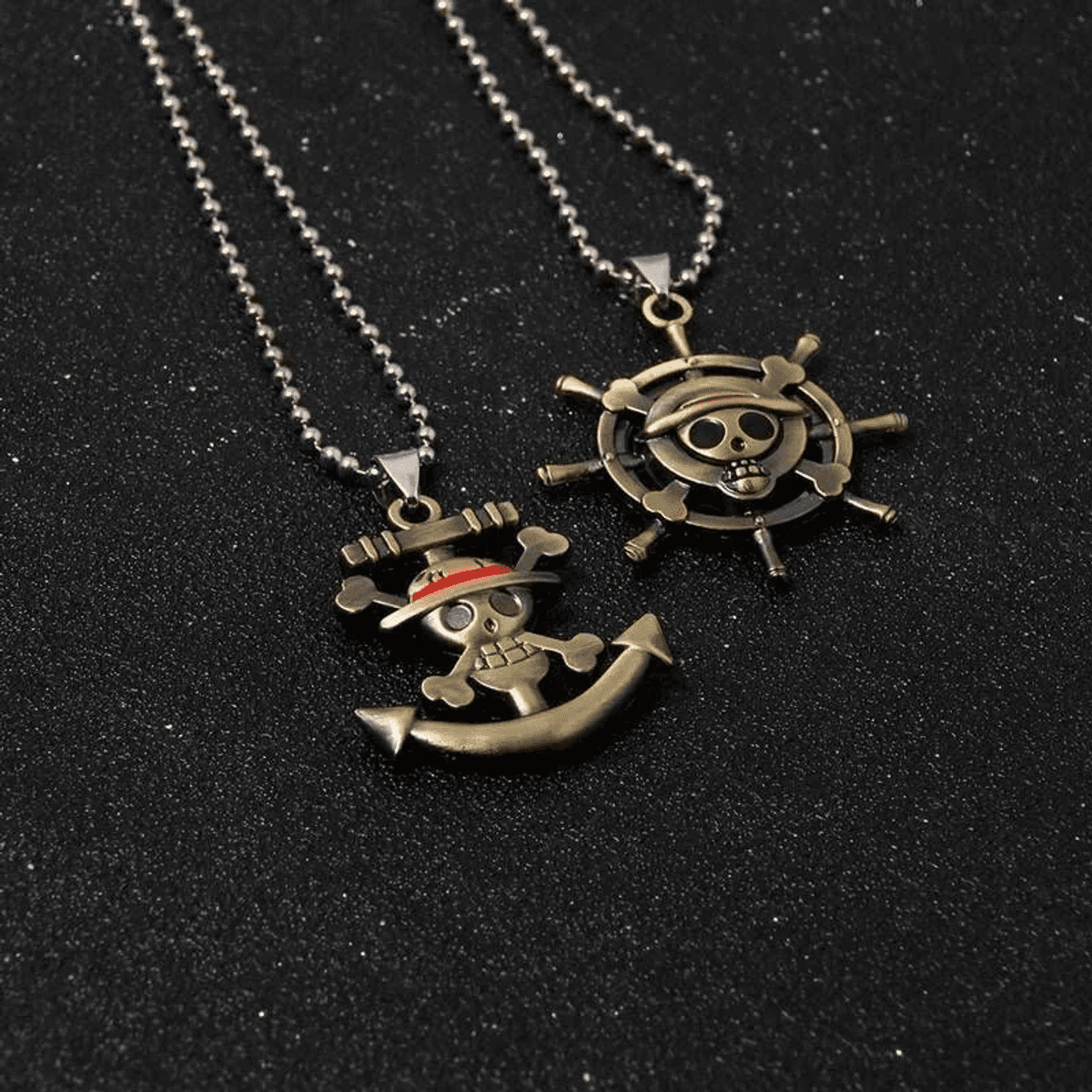 Dos collares con colgantes de calavera sobre fondo negro.