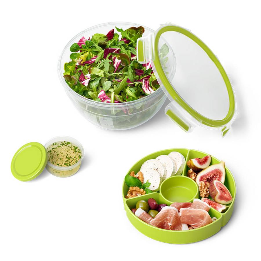 Grüne Salatbox, kleiner Behälter mit Dip und eine grüne Schale mit Snacks.