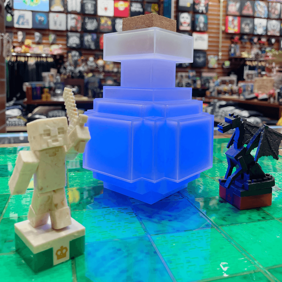 Un esqueleto y un dragón de Minecraft junto a una botella de poción azul brillante.