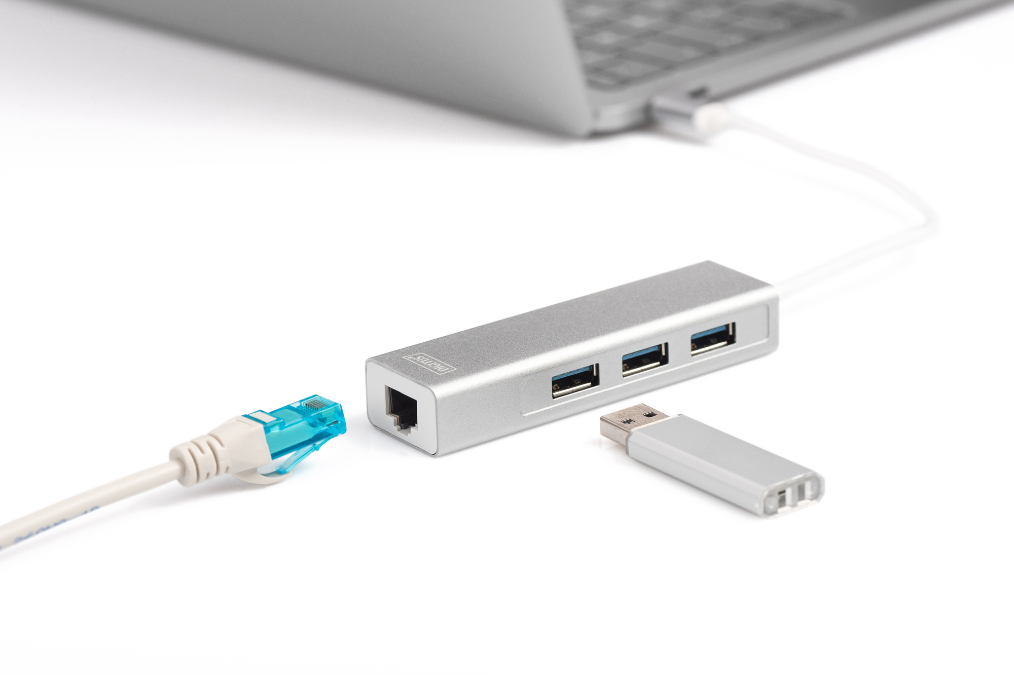 Een zilveren USB-hub met kabels en een USB-stick op witte achtergrond.
