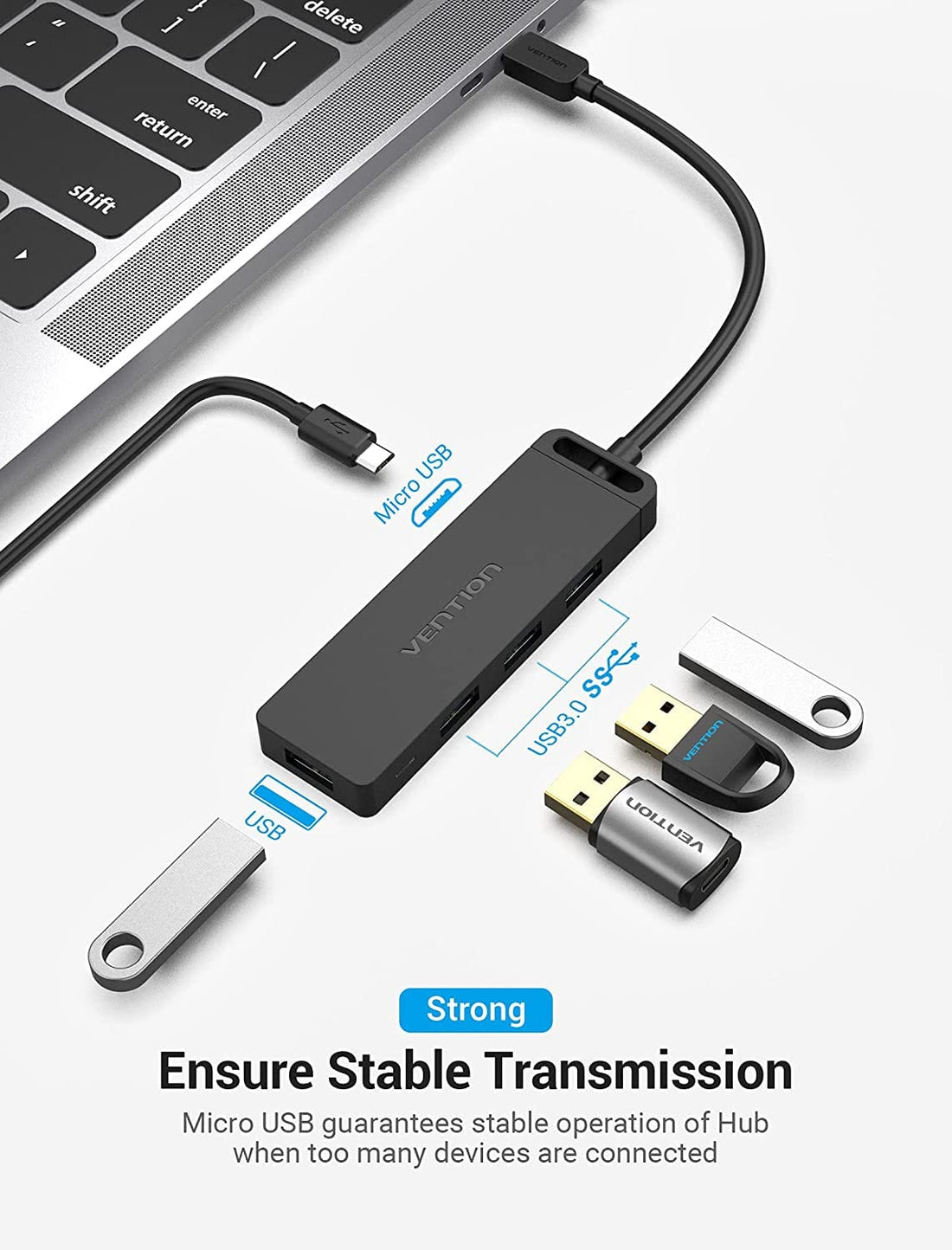 Un concentrador USB negro se conecta a un portátil mediante Micro-USB, con tres unidades USB cerca.