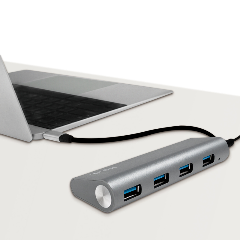 Eine silberne USB-Hub mit vier Anschlüssen ist an einen Laptop angeschlossen.