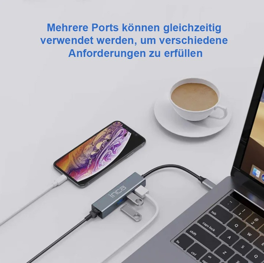 Ein Laptop, eine Maus, ein Handy und ein USB-Hub mit Kaffee.