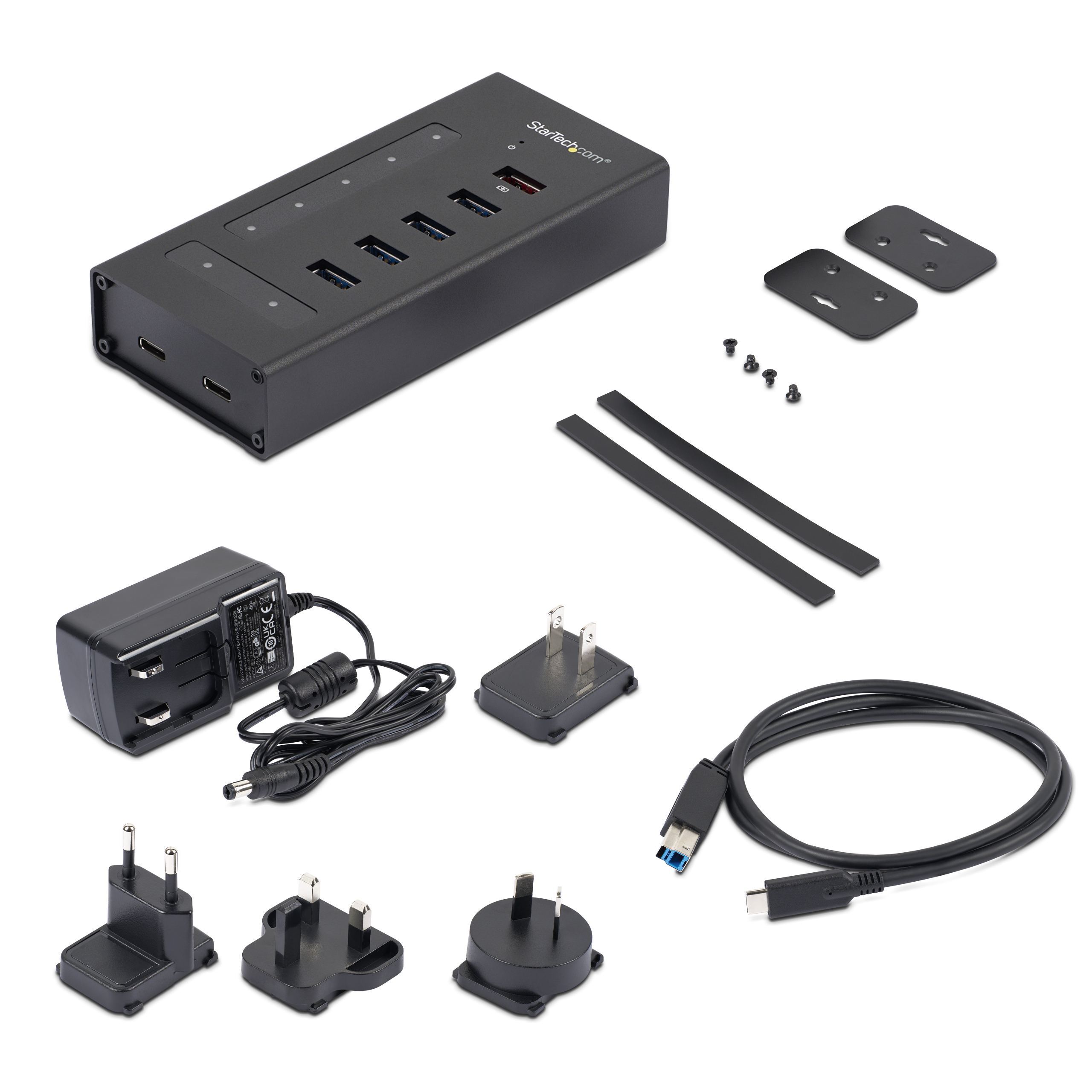 Hub USB nero con adattatore di alimentazione, cavi e varie spine.