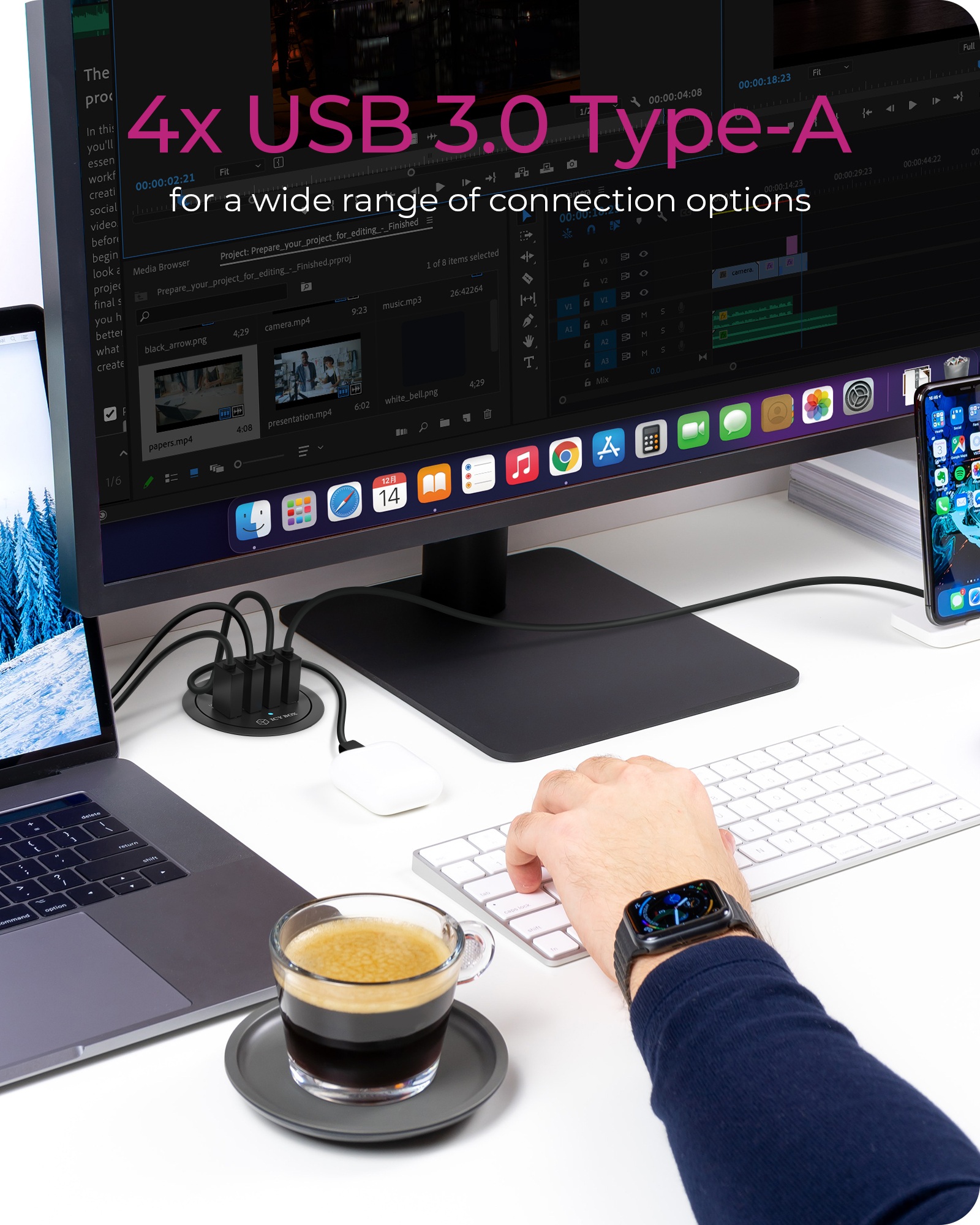 Una scrivania con laptop, monitor, hub USB e tastiera. Caffè in un bicchiere.