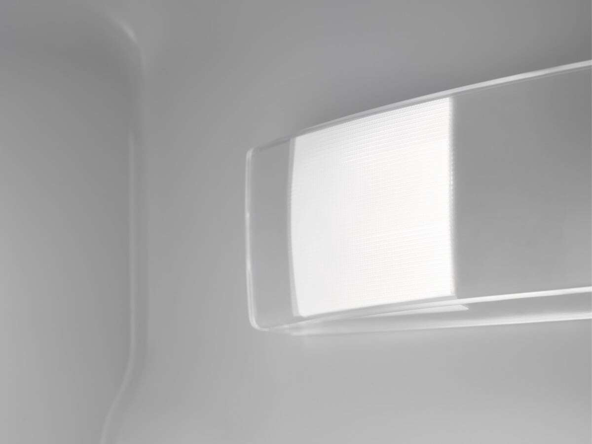 Primo piano di una copertura luminosa bianca e testurizzata in un interno grigio chiaro.