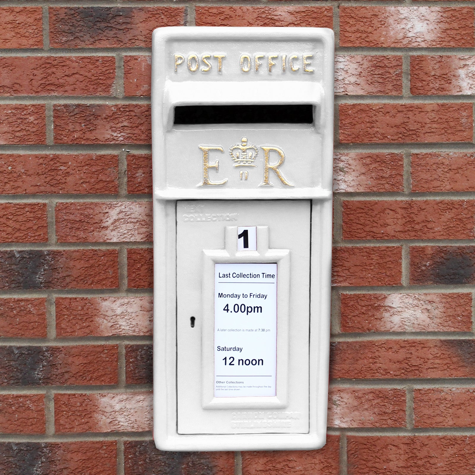 Un buzón blanco en una pared de ladrillos con horarios de recogida.