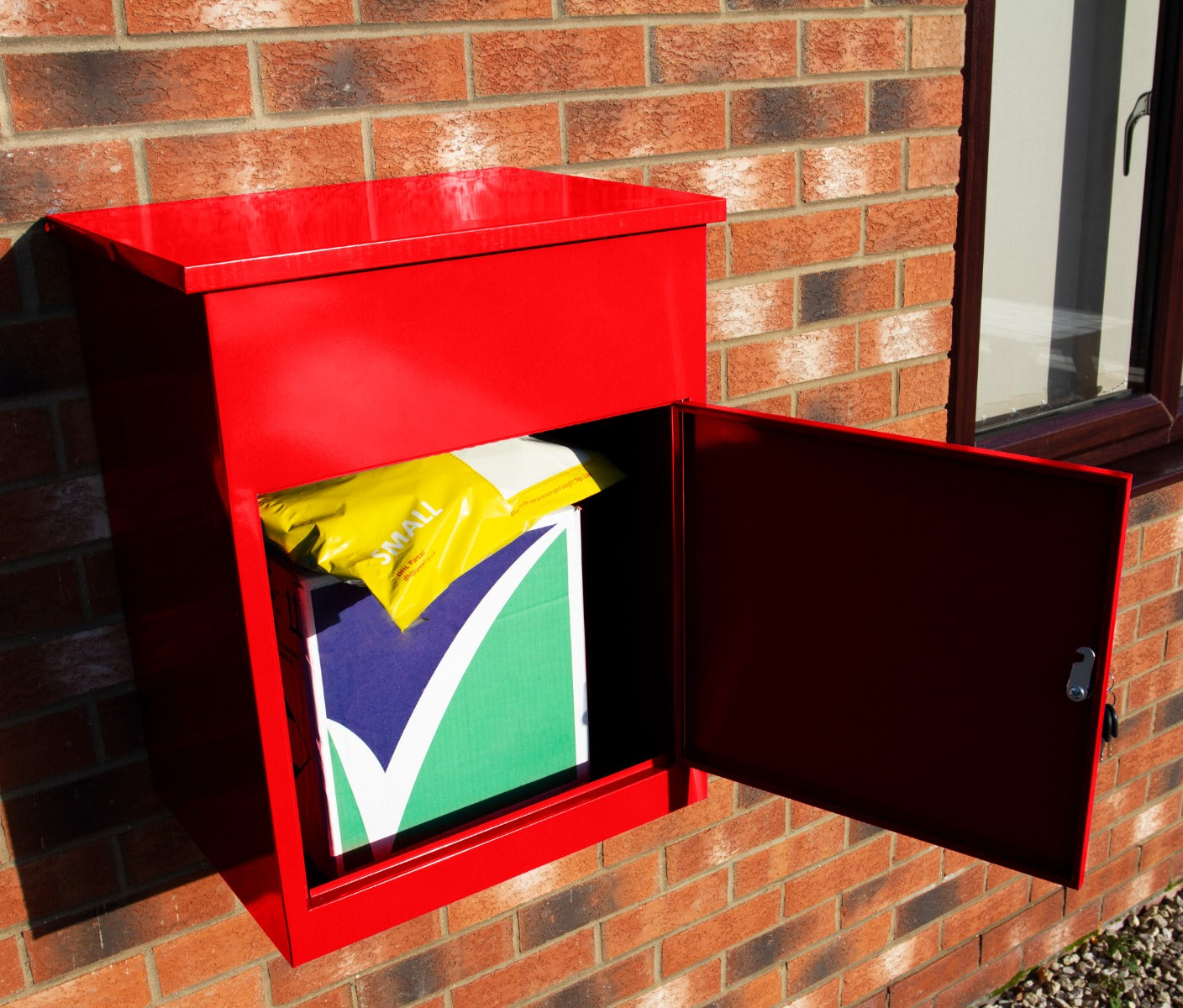 Buzón rojo con puerta abierta, que contiene paquetes y un sobre amarillo.