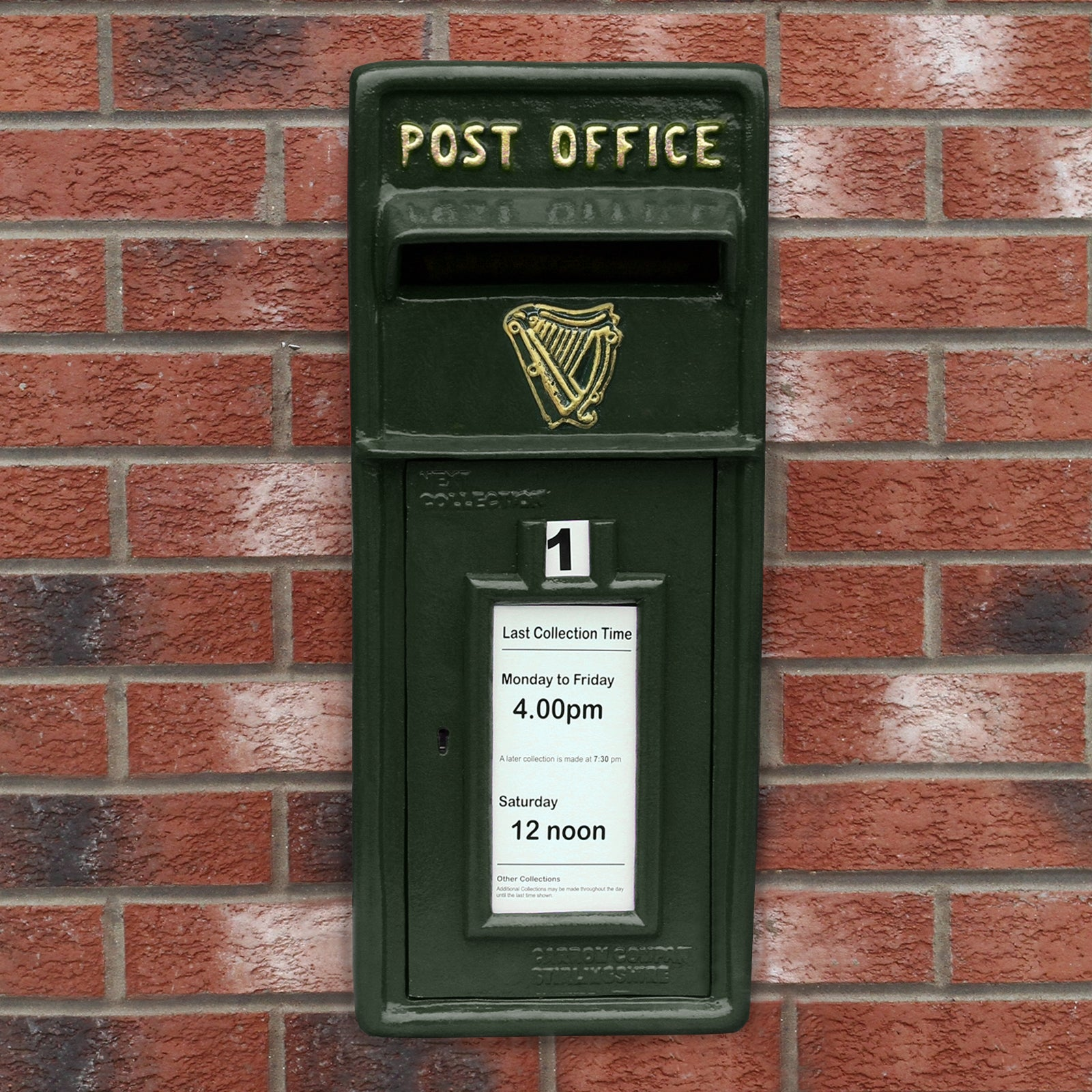 Buzón verde oscuro con inscripción dorada 'POST OFFICE' en pared de ladrillos.