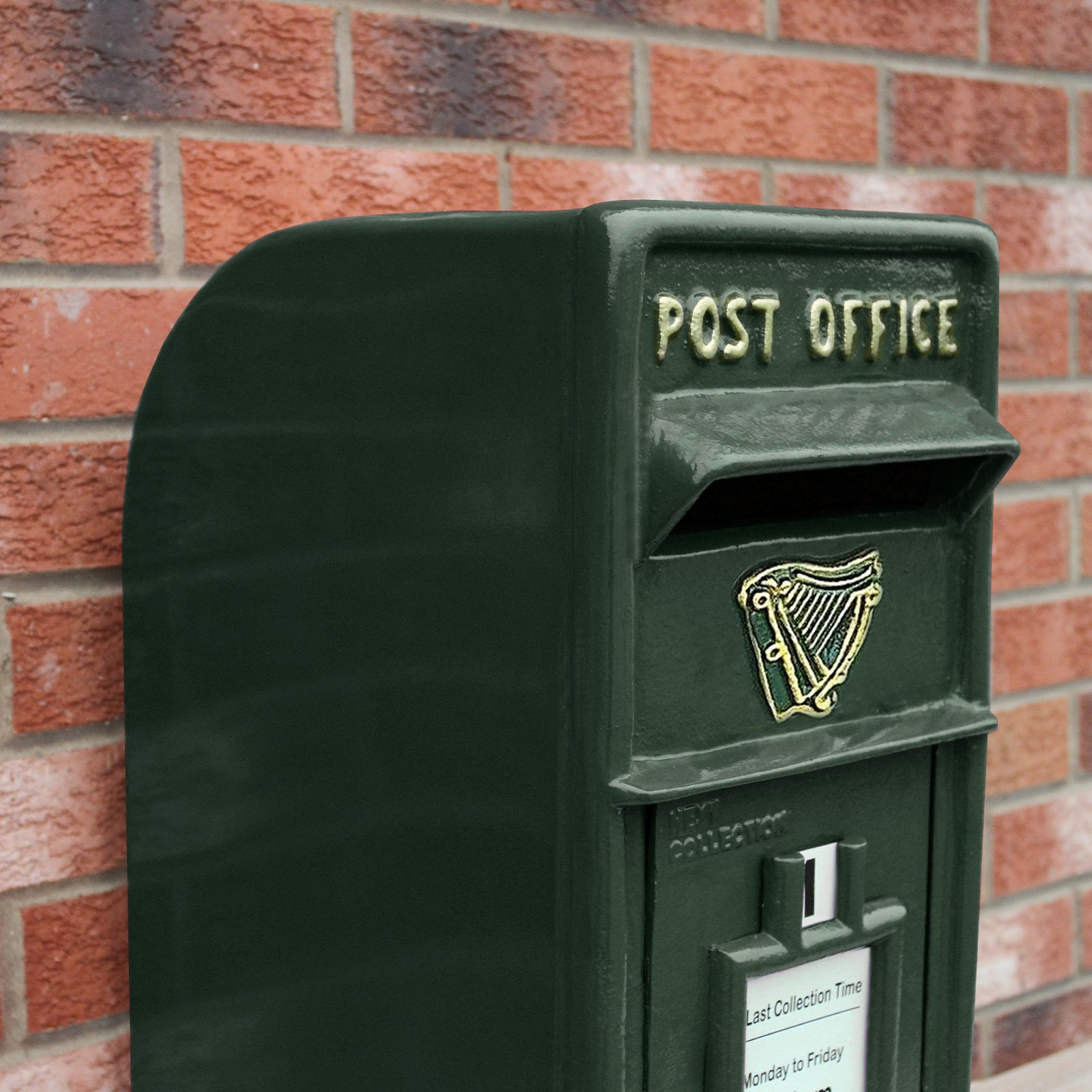 Buzón verde oscuro con letras doradas "POST OFFICE" y emblema de arpa.