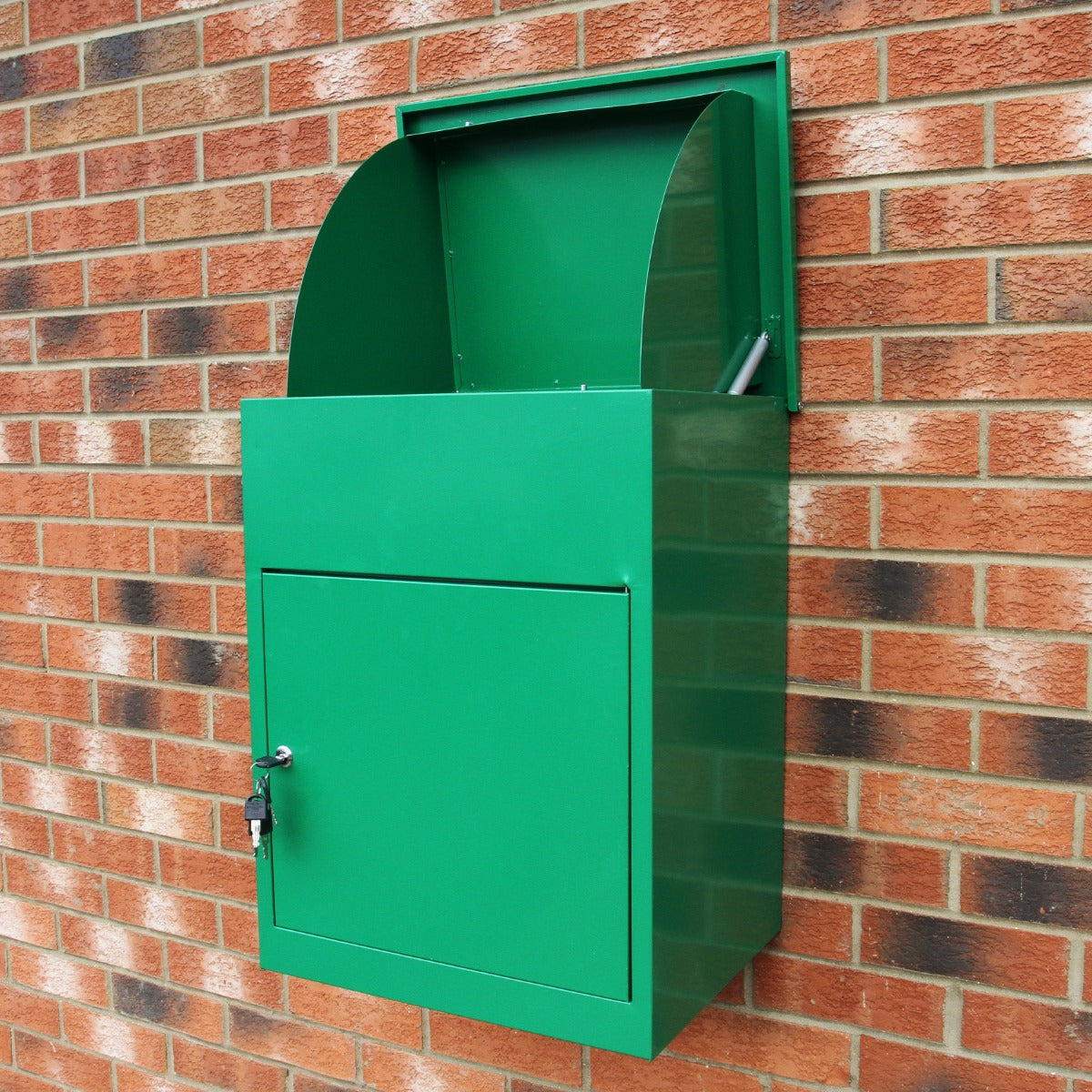 Caja de paquetes verde con tapa y llave montada en pared de ladrillos.