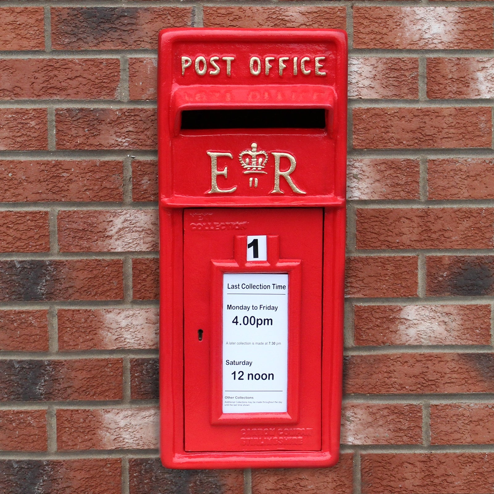 Un buzón rojo con 'Post Office' y símbolo ER, montado en una pared de ladrillos.