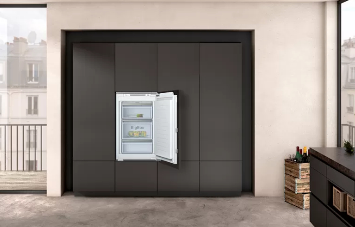 Ein offener Kühlschrank mit drei Schubladen steht in einer modernen Küche.