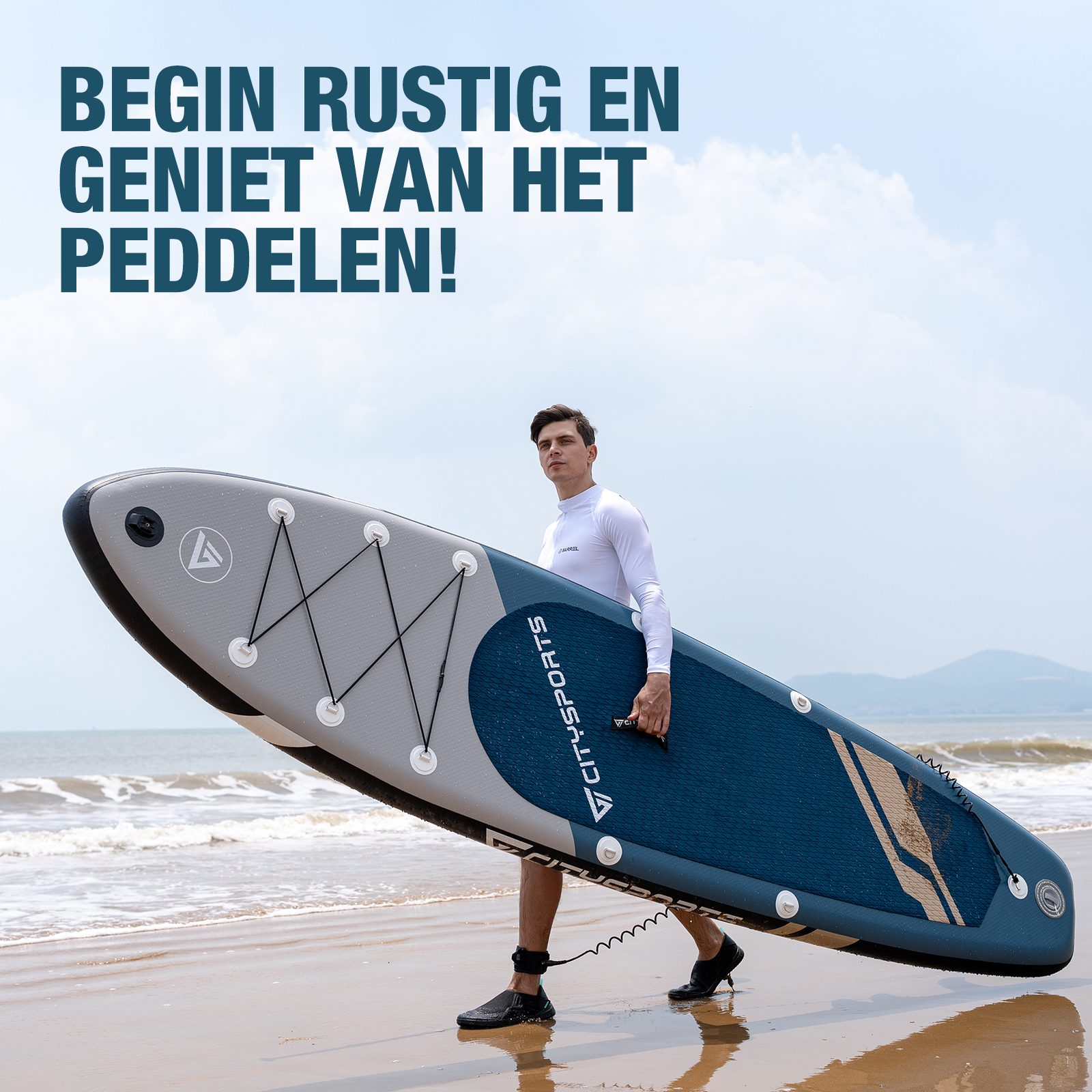 Man draagt een sup board op het strand. Blauw en grijs board.