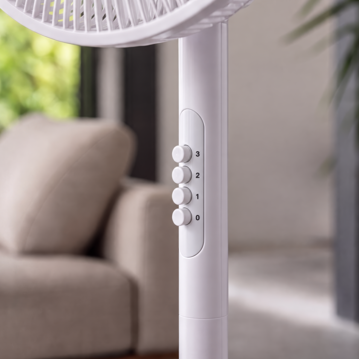 Un ventilatore da terra bianco con pulsanti di controllo e un divano.