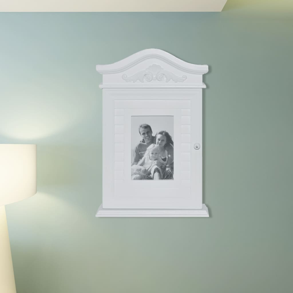Ein weißer Schrank mit einem Familienfoto hängt an einer mintgrünen Wand.
