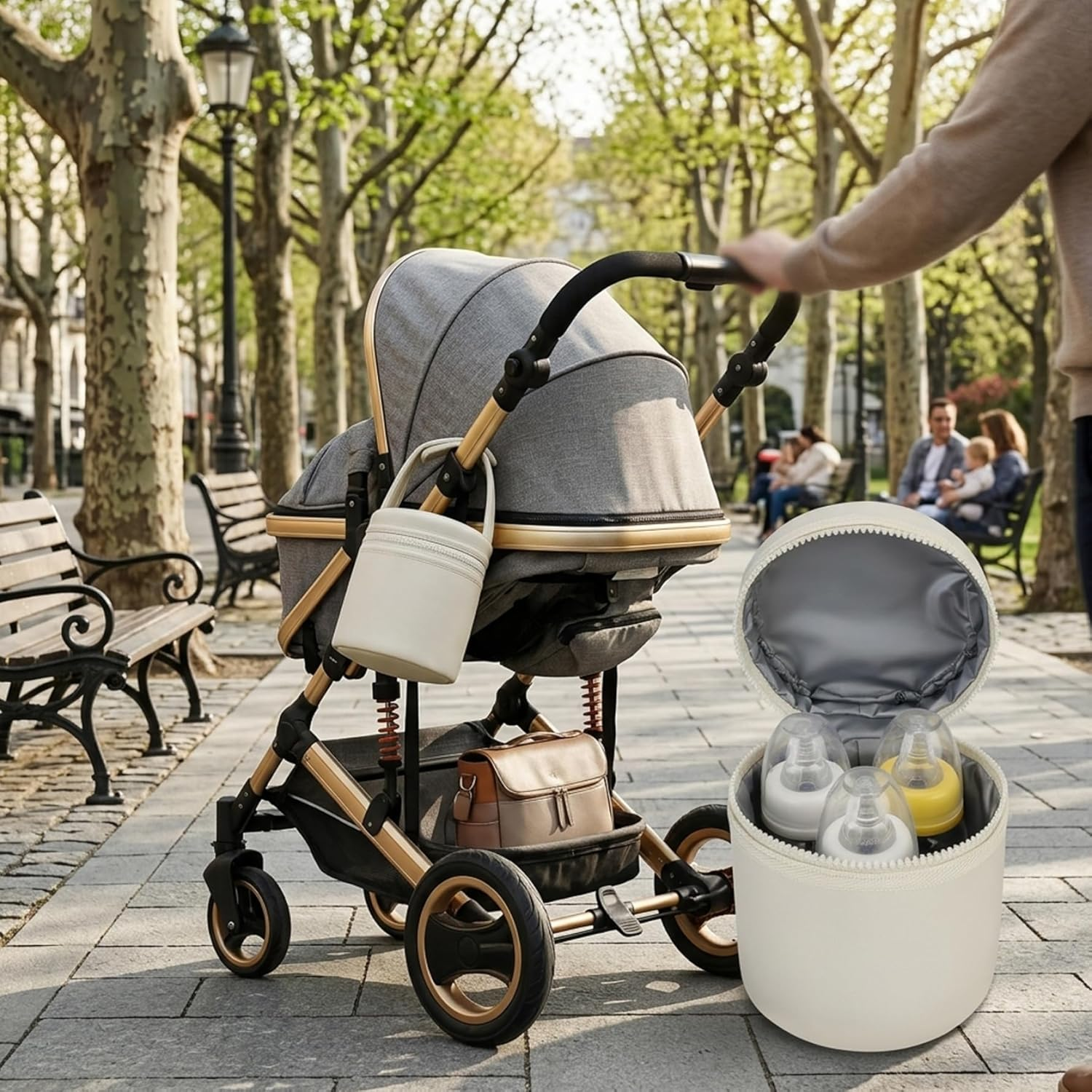 Ein Kinderwagen steht auf einem Gehweg mit Bänken und Bäumen. Daneben ein Behälter mit Babyflaschen.