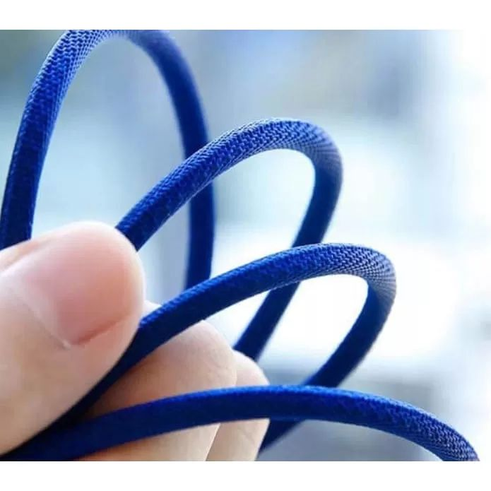 Eine Hand hält ein blaues Kabel mit geflochtenem Muster, unscharfer Hintergrund.