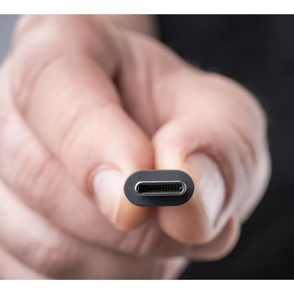 Zbliżenie na złącze USB-C trzymane przez palce.