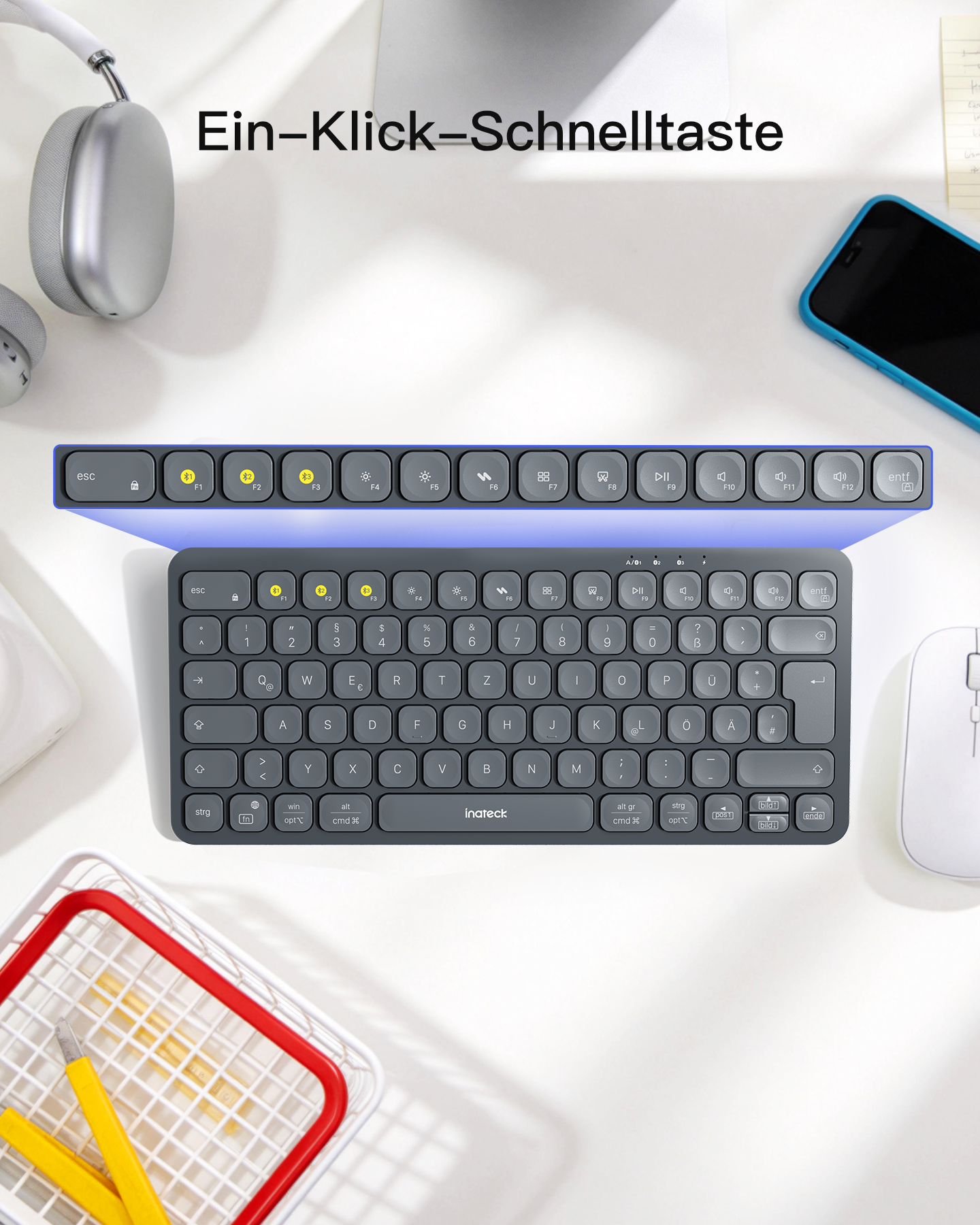 Ein dunkler Schreibtisch mit Tastatur, Maus, Kopfhörern und Smartphone.