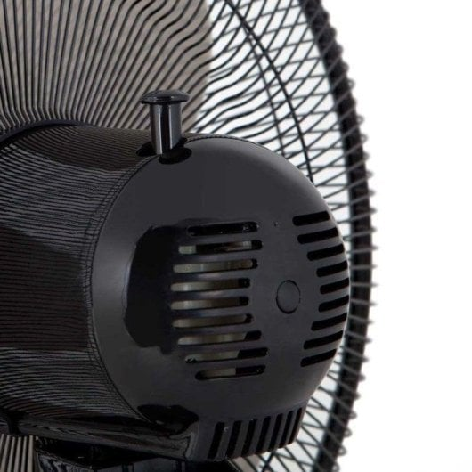 Primer plano de un ventilador negro con rejillas y un botón.