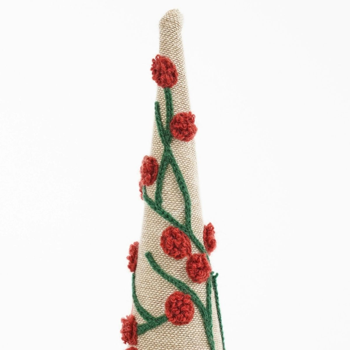 A cone-shaped decoration made of beige fabric with green vines and red flowers.