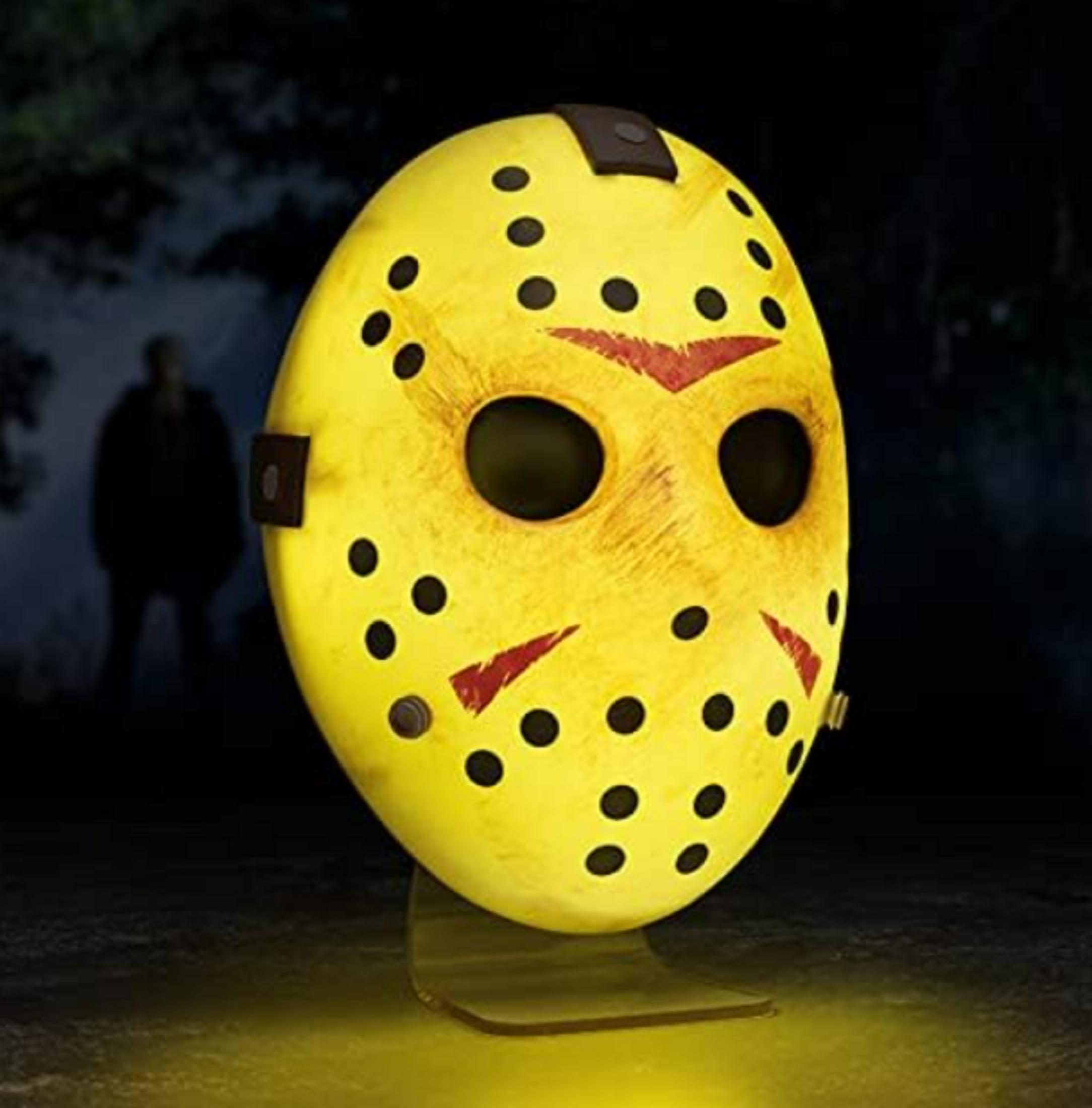 Ein gelber Hockeymasken-Schreibtisch mit schwarzen Löchern und roten Akzenten.