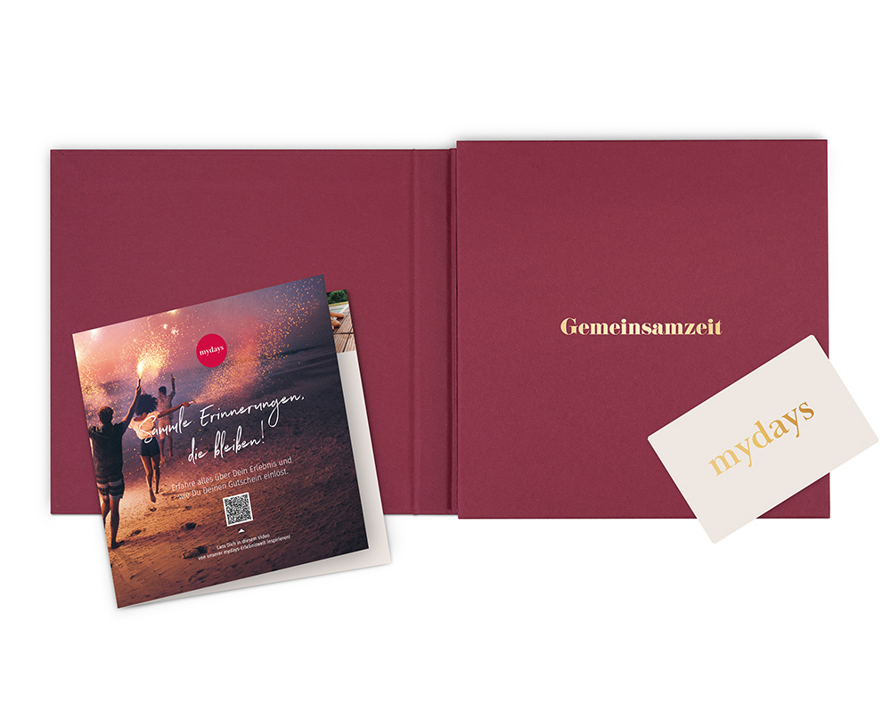 Ein offenes Buch mit Broschüre und Karte. Gedruckt in rot.