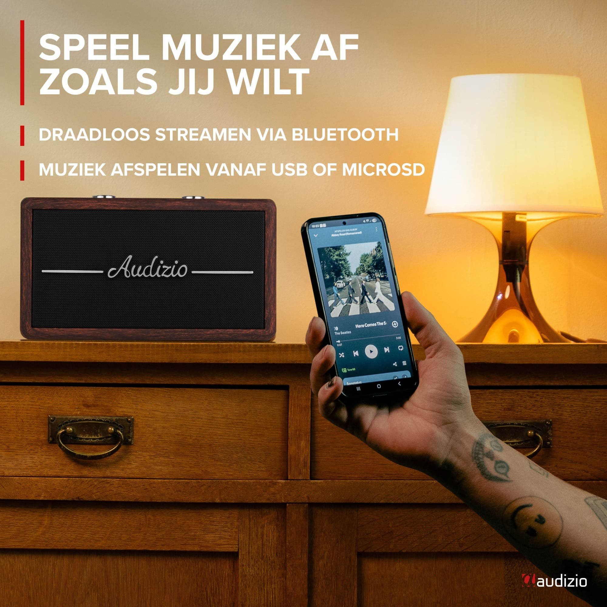 Un altavoz y un smartphone con app de música en un mueble de madera.