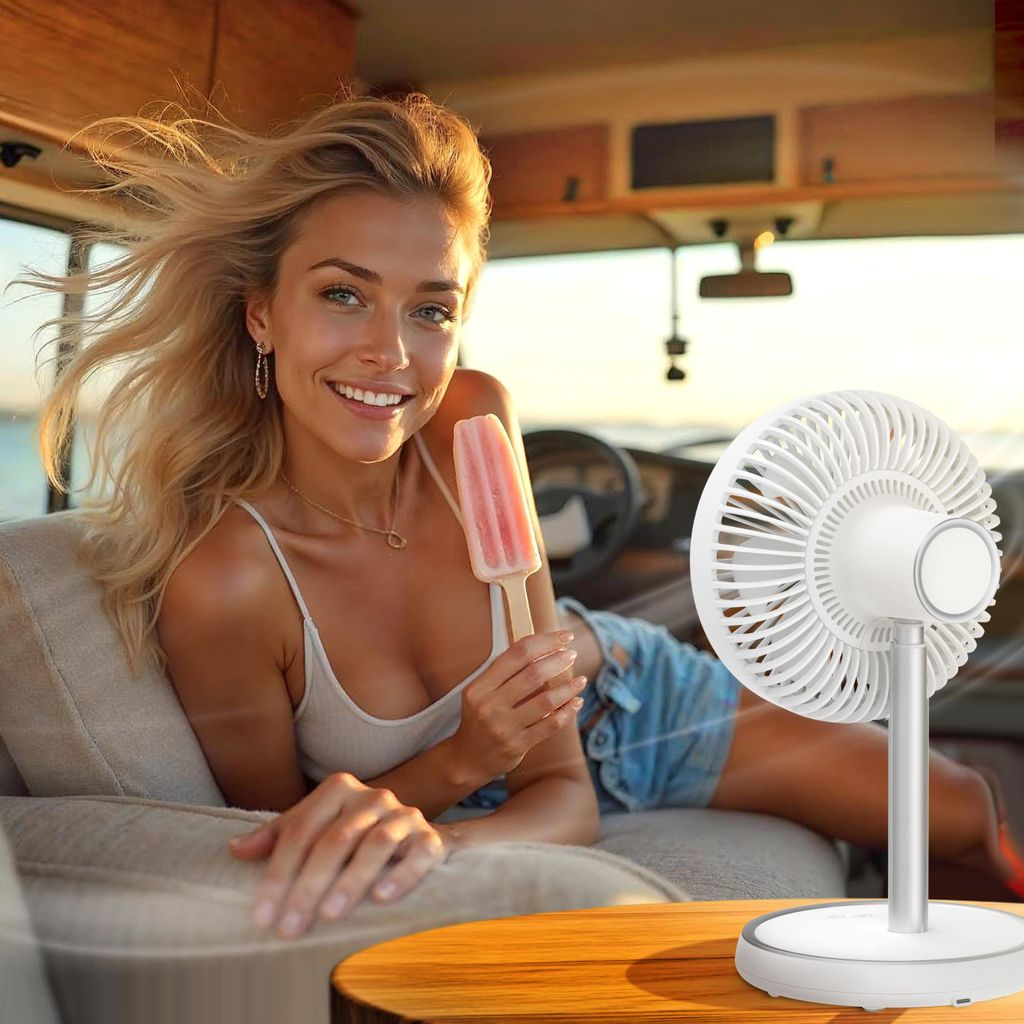 Eine Frau mit blonden Haaren isst Eis in einem Wohnmobil, ein Ventilator steht daneben.