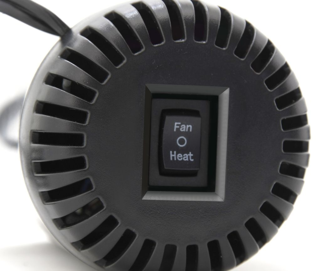 Schwarzer Schalter mit "Fan" und "Heat" Beschriftung auf Lüftergitter.