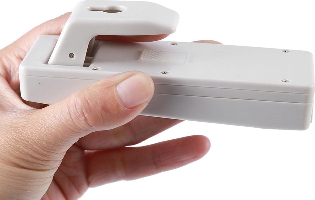 Eine Hand hält ein weißes elektronisches Gerät mit einem ausklappbaren Teil.
