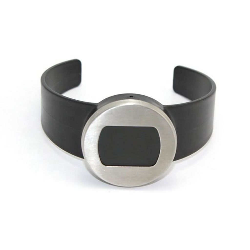 Ein schwarzes Manschettenarmband mit einem silberfarbenen kreisförmigen Mittelstück und schwarzer rechteckiger Einlage.